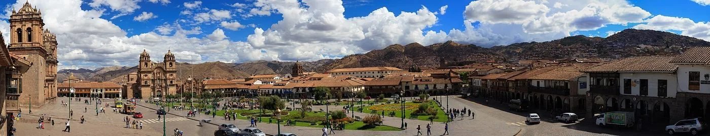 Steep cobbled street on the Santa Ana side of Cusco with tiled roofs and the hills behind