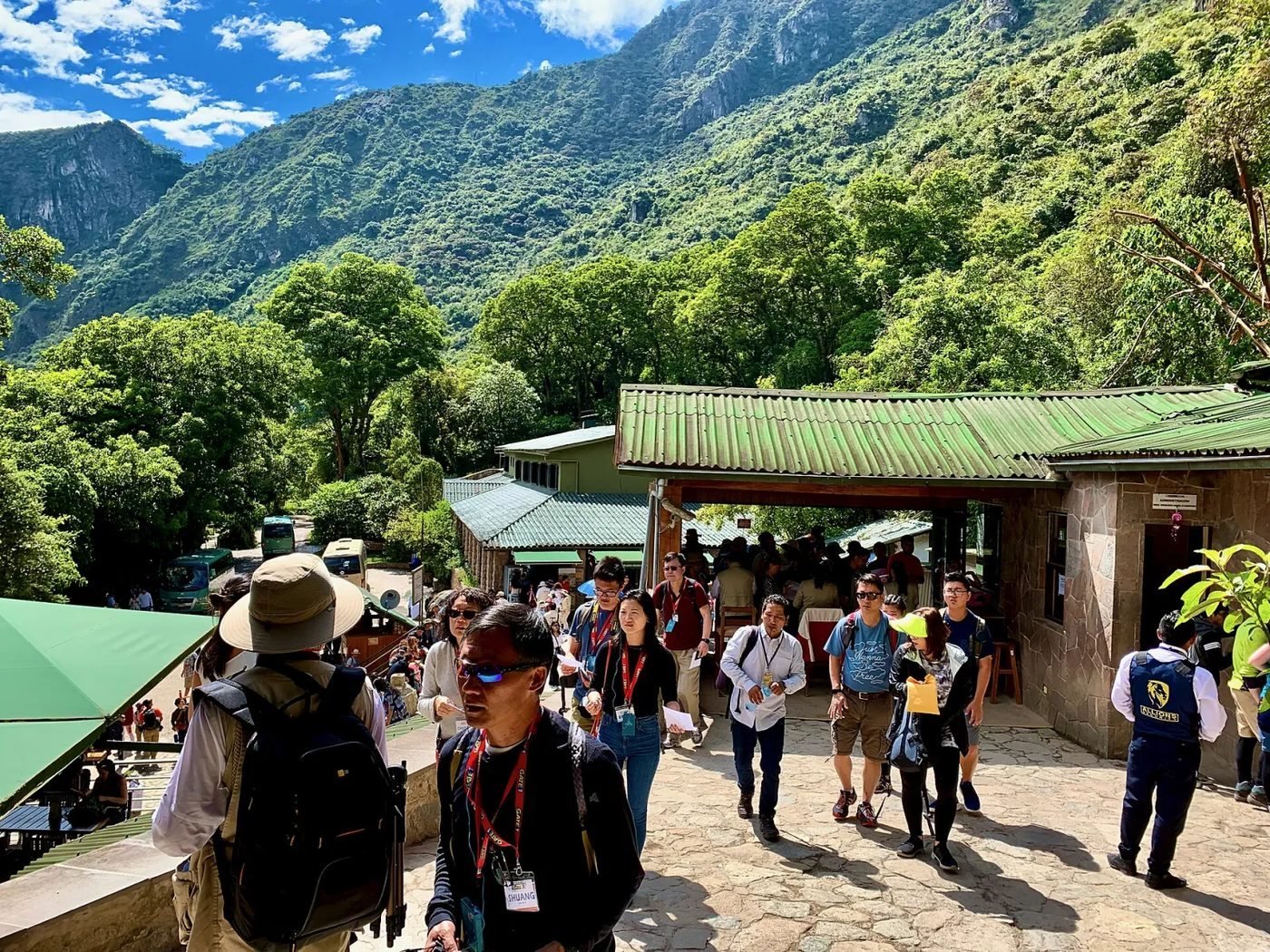 Visitors with tickets in hand at the Machu Picchu entrance gate in early morning light