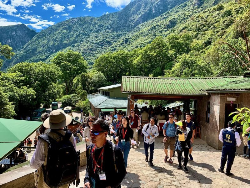 Visitors with tickets in hand at the Machu Picchu entrance gate in early morning light