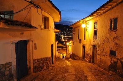 San Blas at dusk, Cusco Steep cobbled street in San Blas at dusk with city lights of Cusco below