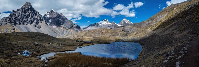 Small blue lake and a tent below jagged peaks on the Ausangate trek