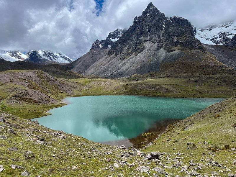 Turquoise lake below a dark rocky peak on the Ausangate seven lakes loop
