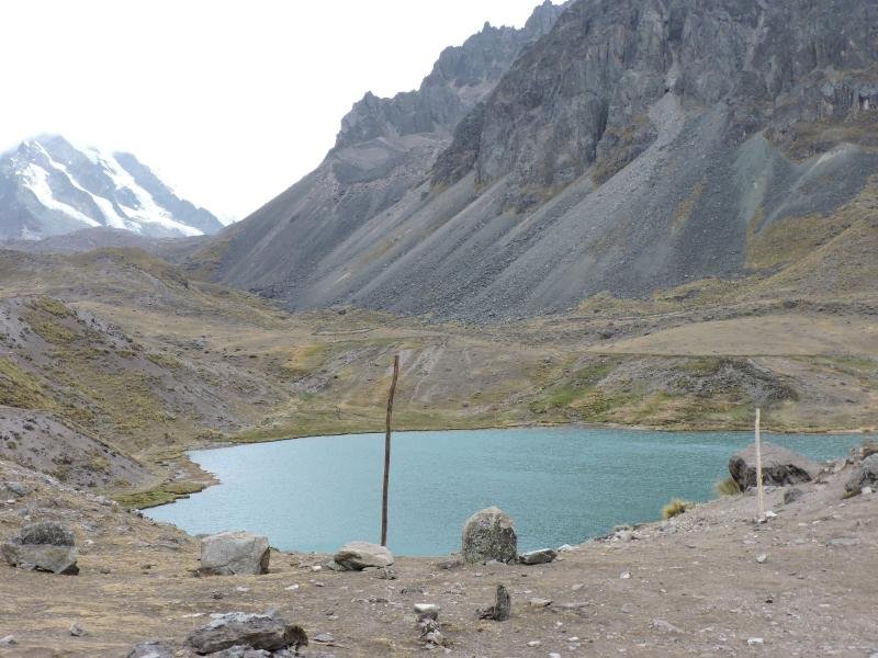 Glacial lake below gray scree slopes near Nevado Ausangate