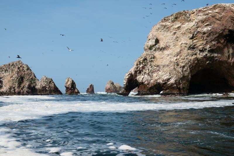 Ballestas Islands, Paracas Rock arches of the Ballestas Islands seen from the boat, with seabirds overhead