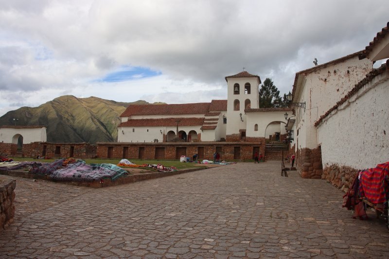 Colonial church of Chinchero above a cobbled square where weavers lay out textiles