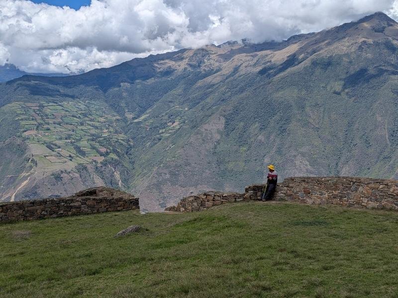 Visitor at a stone wall in Choquequirao looking across the Apurimac canyon