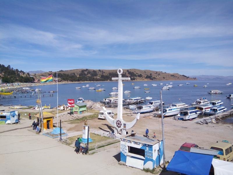 Harbor of Copacabana with tour boats and the anchor monument on the shore of Lake Titicaca