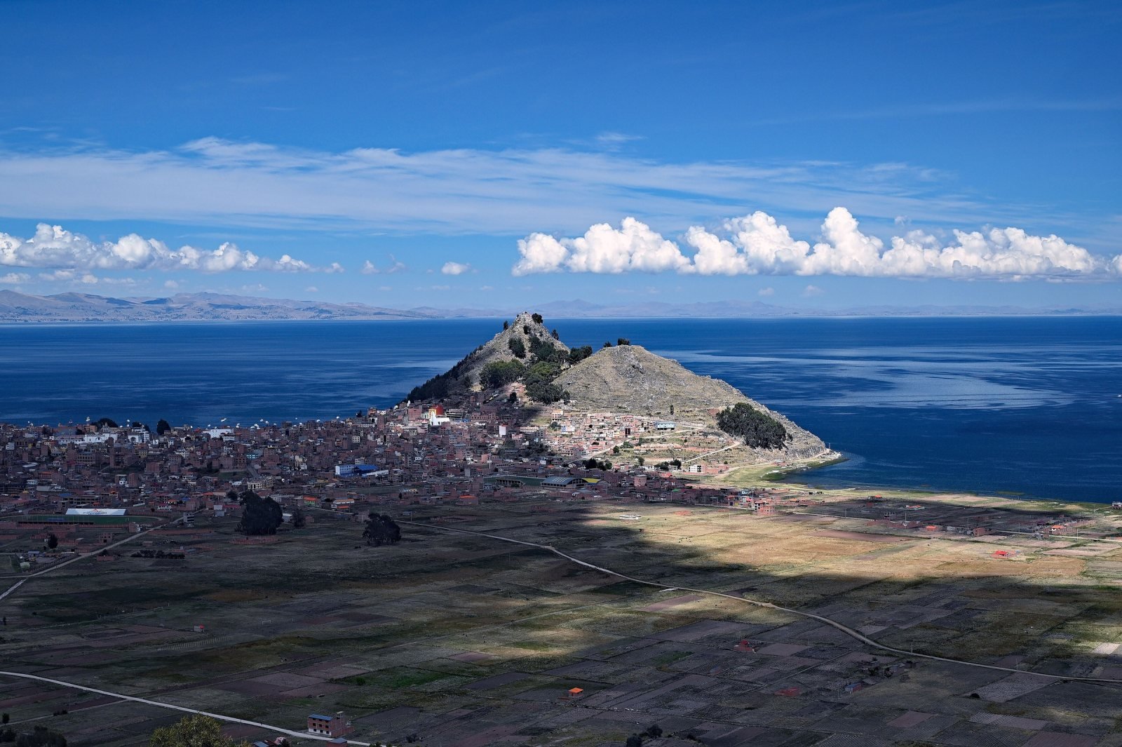 Copacabana bay on Lake Titicaca with tour boats moored below the hills