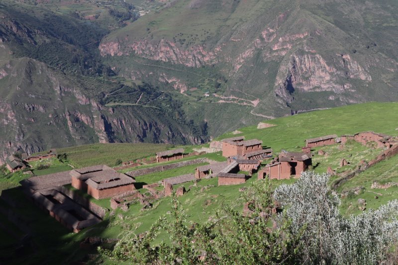 Adobe buildings and terraces of Huchuy Qosqo on a ledge above the Sacred Valley