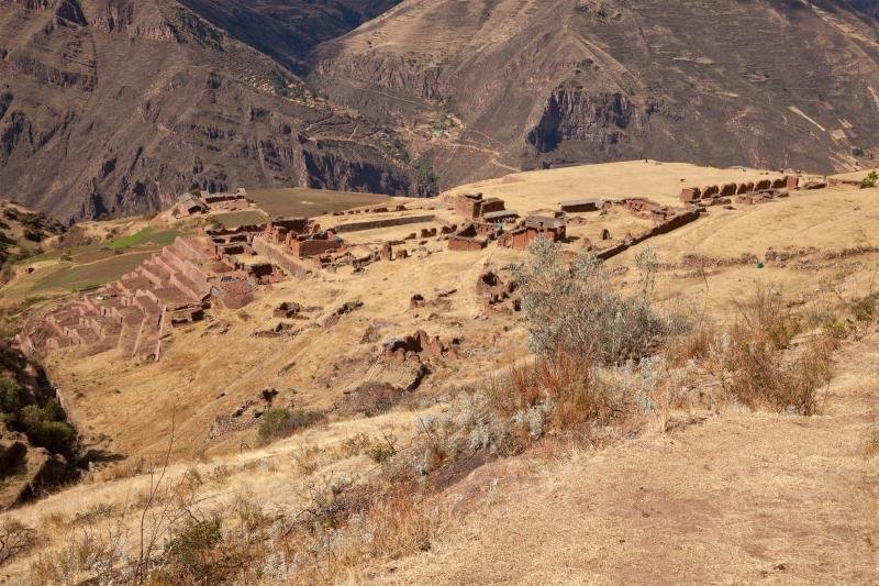Ruins of Huchuy Qosqo spread across a dry plateau above a deep valley