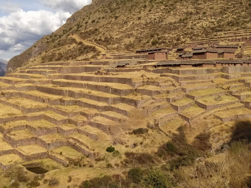 Stepped terraces climbing to the buildings of Huchuy Qosqo