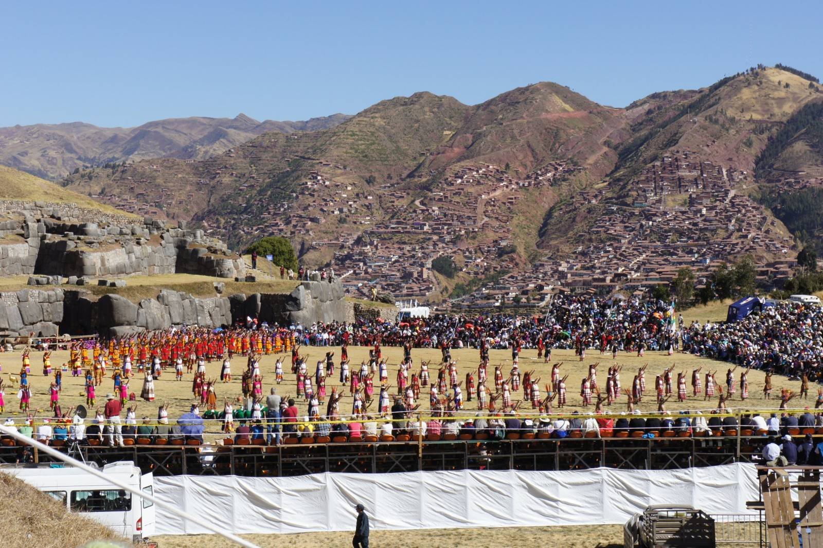 Inti Raymi dancers on the esplanade of Sacsayhuamán in Cusco with the hills behind
