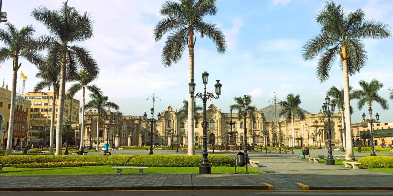 Palm trees and lamp posts across the gardens of Lima's Plaza Mayor