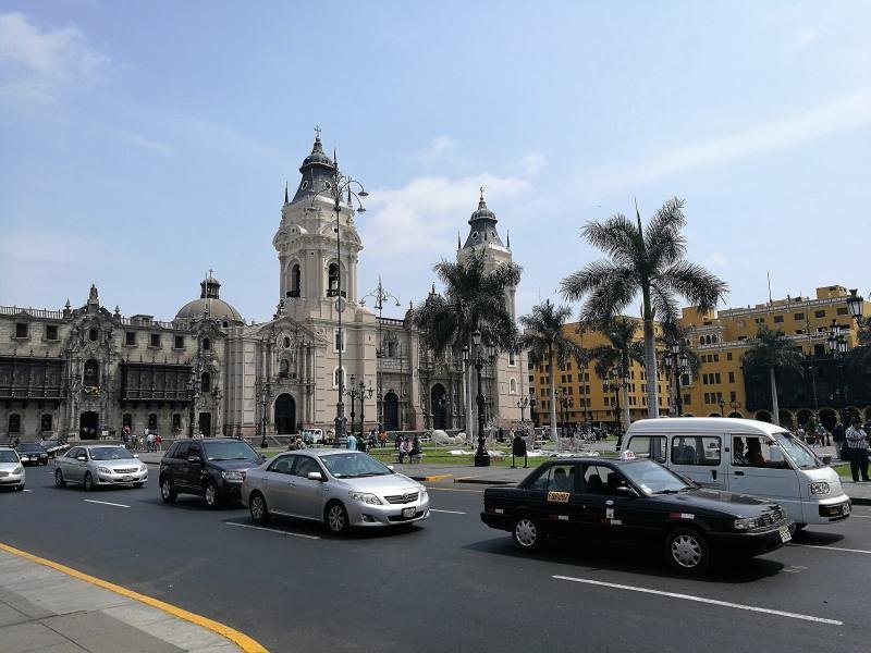 Plaza Mayor of Lima with the cathedral and palm trees under a gray sky