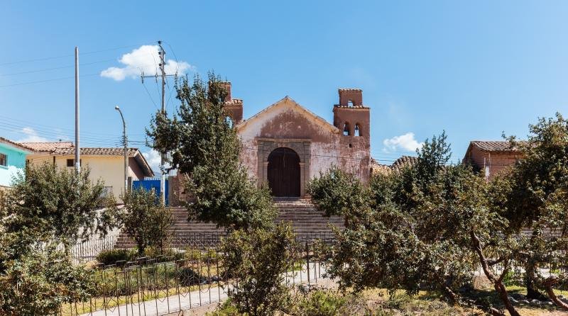 Colonial church of the village of Maras on its plaza under a blue sky