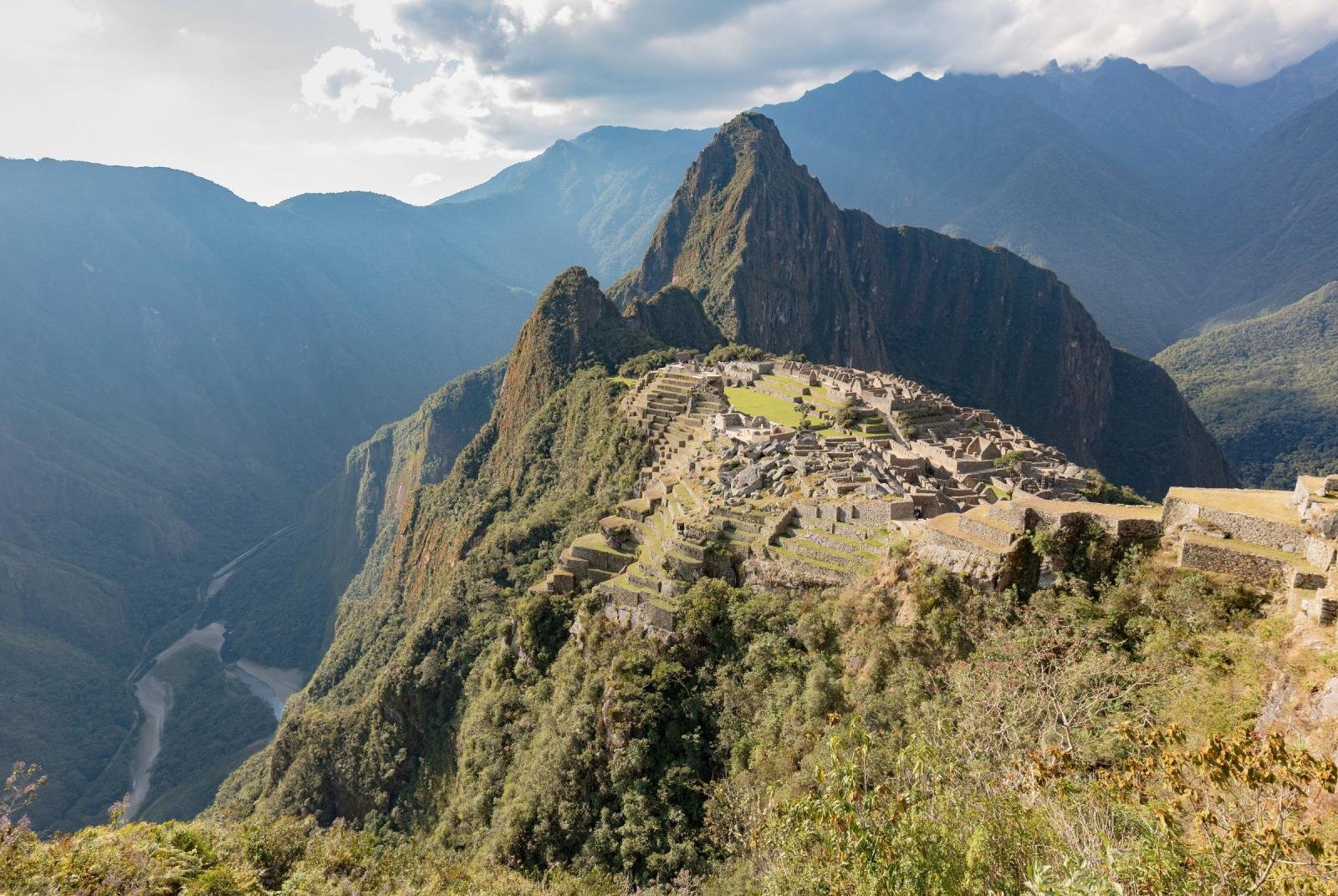 Machu Picchu Machu Picchu on its ridge between Huayna Picchu and the deep Urubamba valley, seen from above in afternoon light