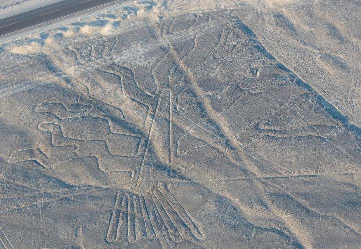 Figure and long straight lines etched into the Nazca pampa seen from above