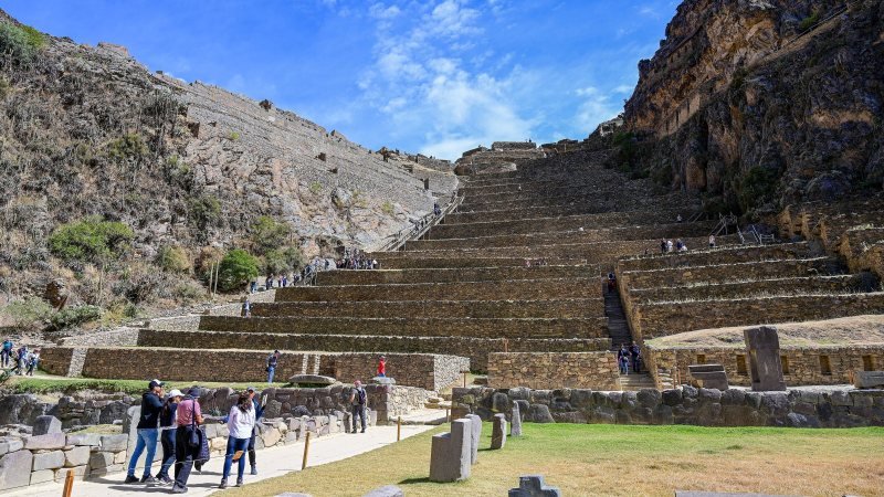 Visitors climbing the stone terraces of the Ollantaytambo temple hill