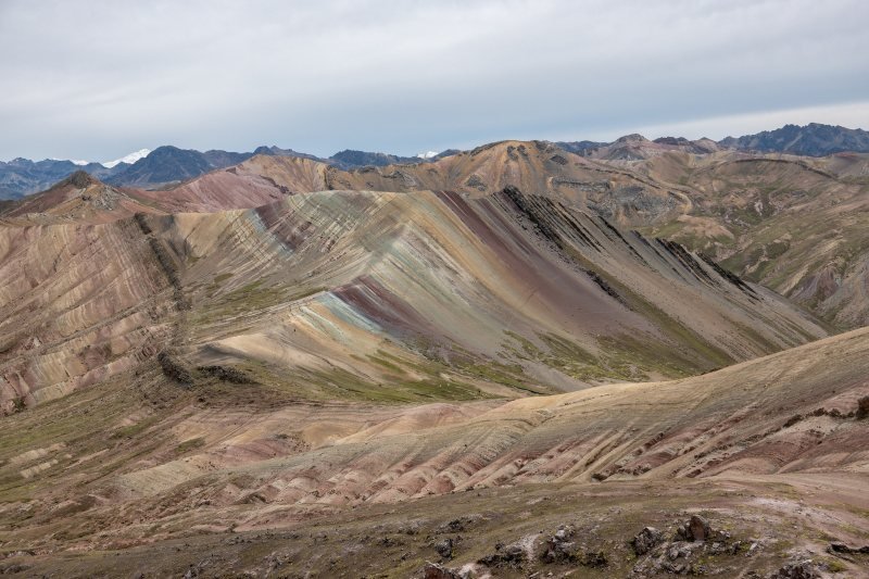 Multicolored folds of the Palccoyo hills under a cloudy sky