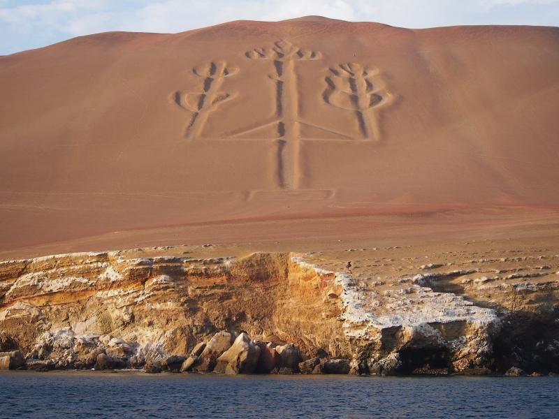 The Candelabra geoglyph carved into a sandy hillside on the Paracas peninsula, seen from the sea