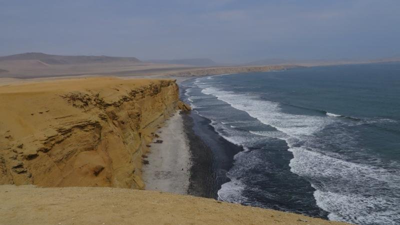 Desert cliffs and dark sand at Playa Supay in the Paracas National Reserve