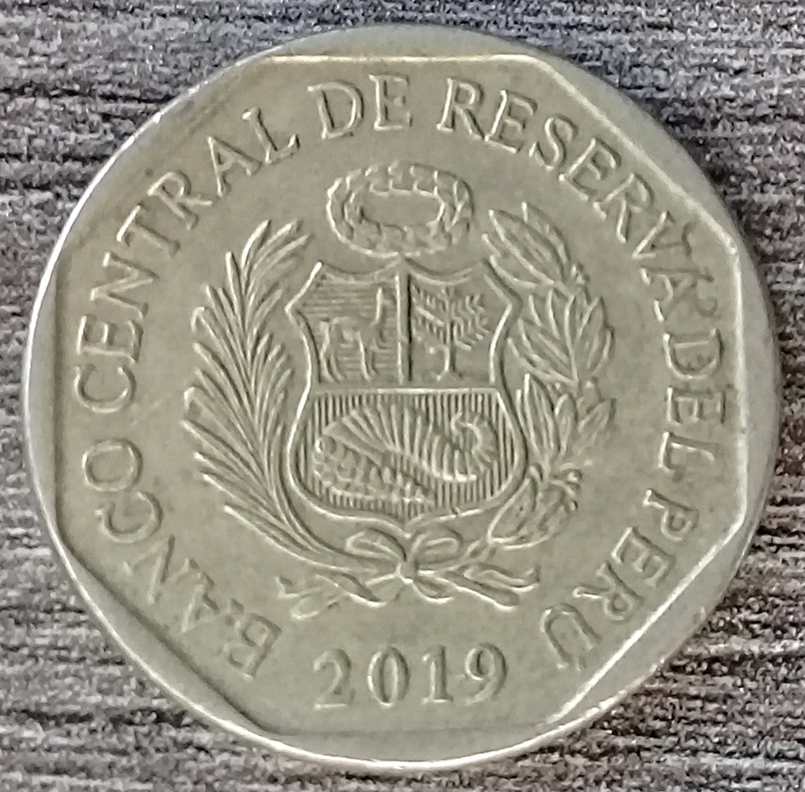 Close-up of a Peruvian 50 centimos coin from 2019 showing the coat of arms and the Banco Central de Reserva del Peru lettering