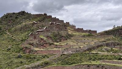 Pisac citadel Stone buildings of the Pisac citadel on a green hillside in the Sacred Valley