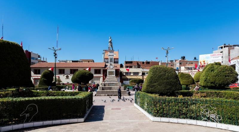 Gardens and monument of the Plaza de Armas in Puno under a clear sky