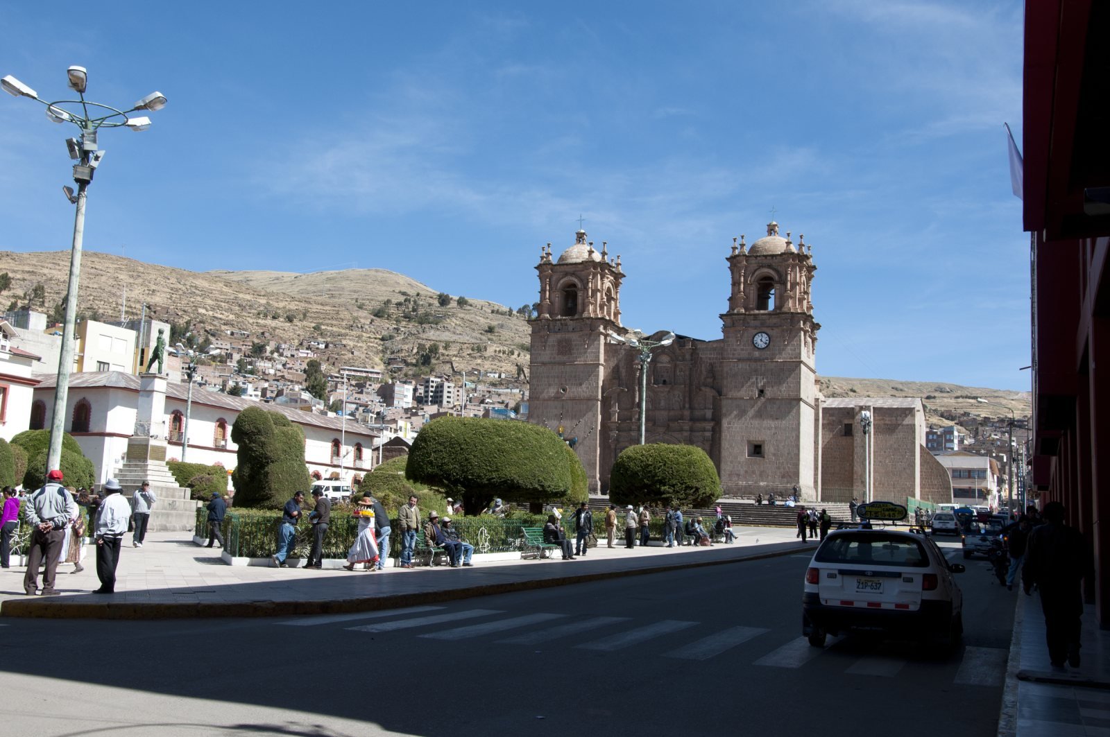 Cathedral of Puno and the trimmed gardens of the Plaza de Armas under a blue sky