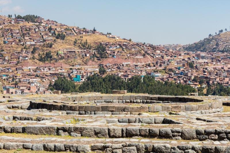 Zigzag stone terraces of Sacsayhuaman with the hillside houses of Cusco behind