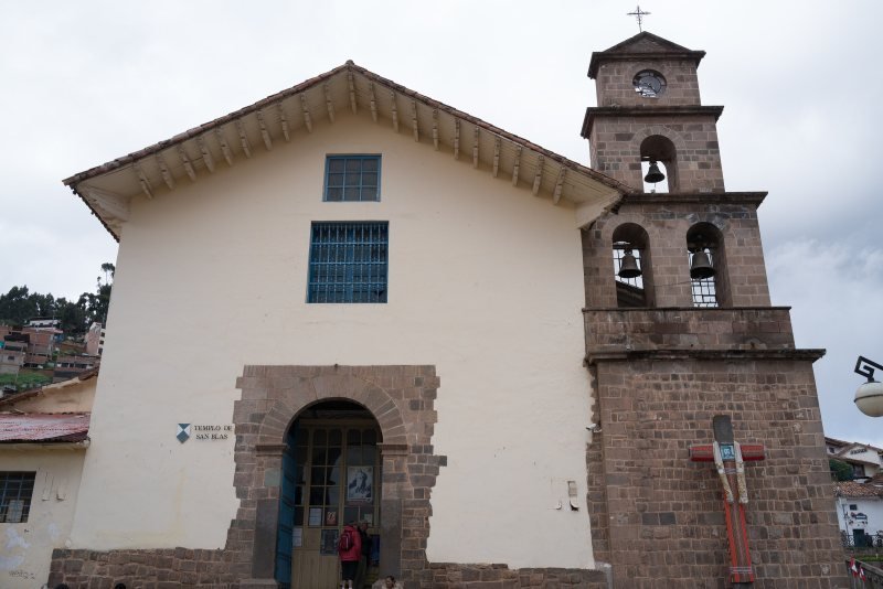Whitewashed San Blas church and its stone bell tower in Cusco