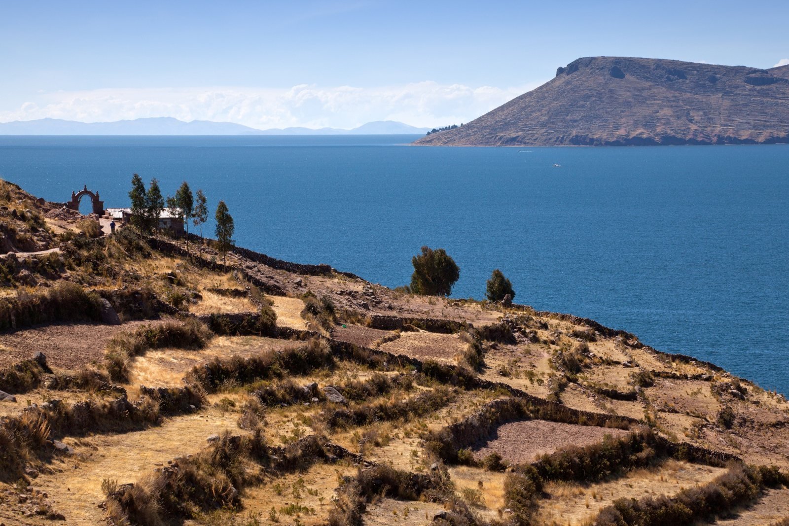 Stone-walled terraces of Taquile above the deep blue water of Lake Titicaca