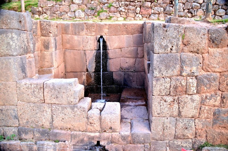 Water falling from a carved stone channel into the ceremonial fountain at Tipon