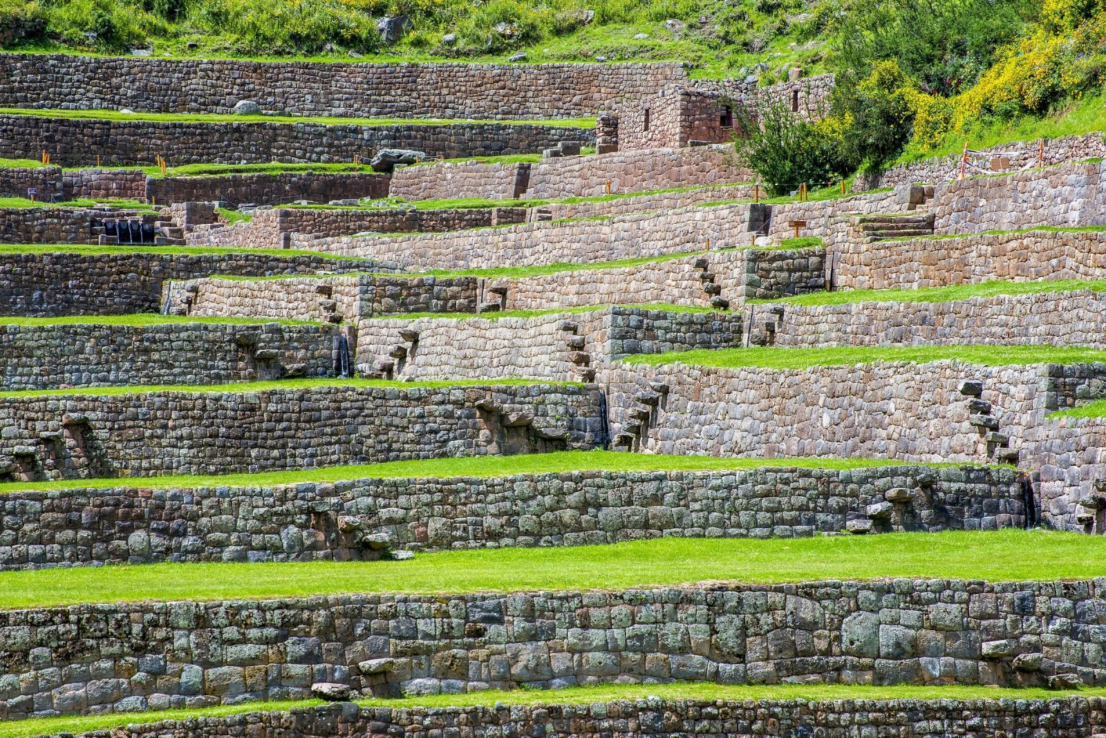 Stone-walled terraces with green lawns stepping down at Tipon