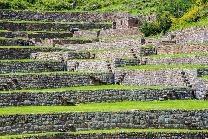 Stone-walled terraces with green lawns stepping down at Tipon