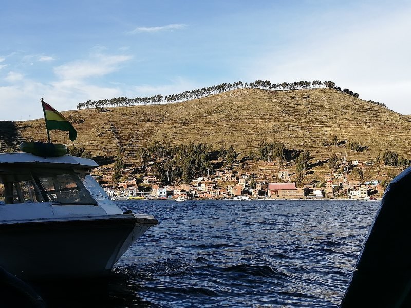 Boat on the Strait of Tiquina with the town of San Pedro de Tiquina behind