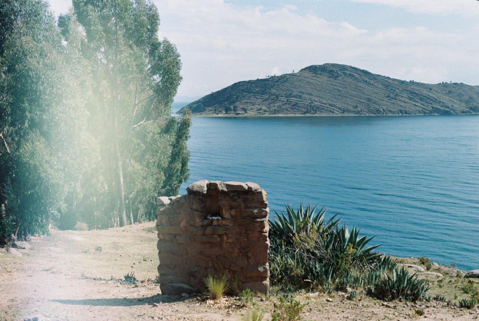 Shore of Lake Titicaca near Capachica with blue water and a green headland