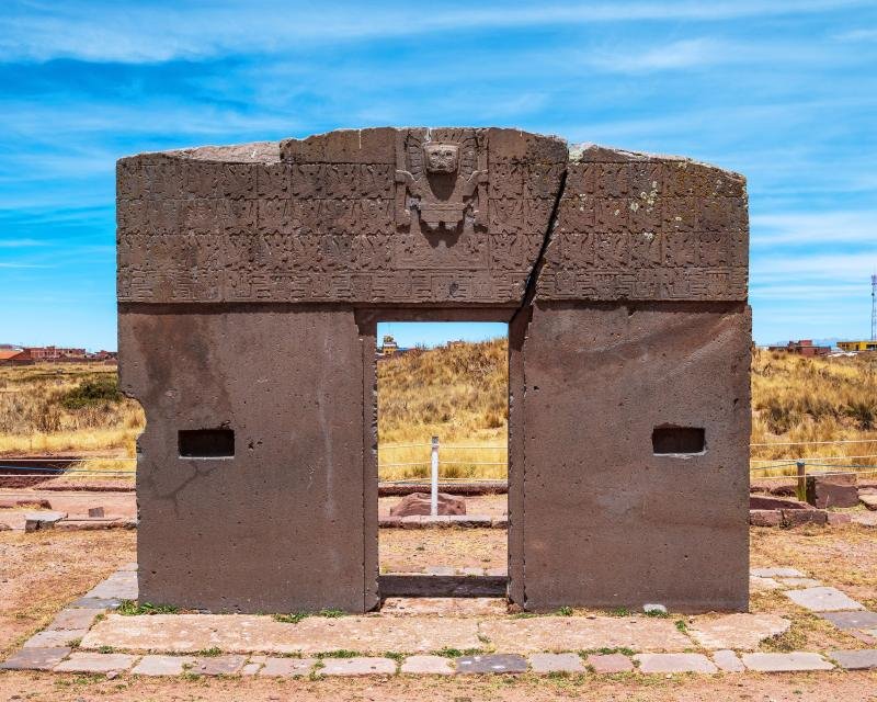 The carved Gate of the Sun at Tiwanaku under a blue sky