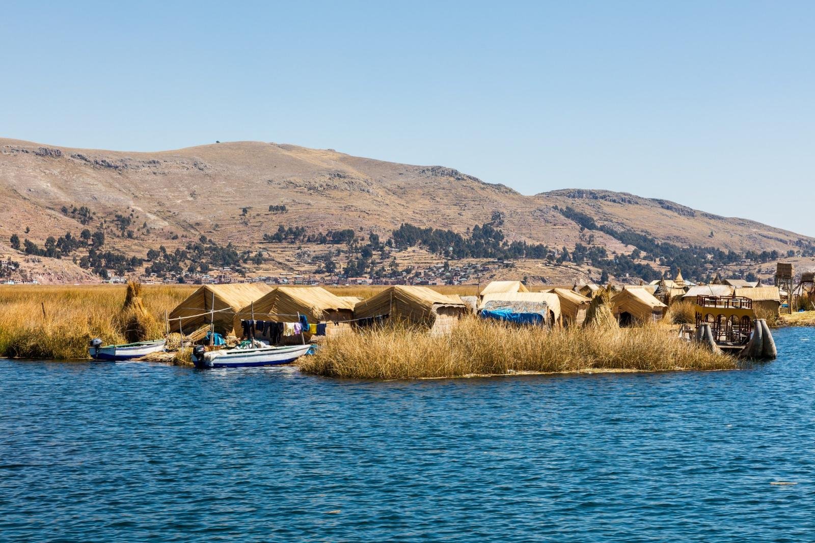 Floating Uros islands with reed houses and boats on Lake Titicaca near Puno