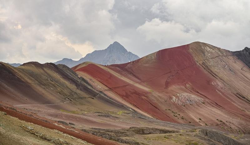 Vinicunca Red Valley ridges beside Vinicunca with a snowy peak on the horizon