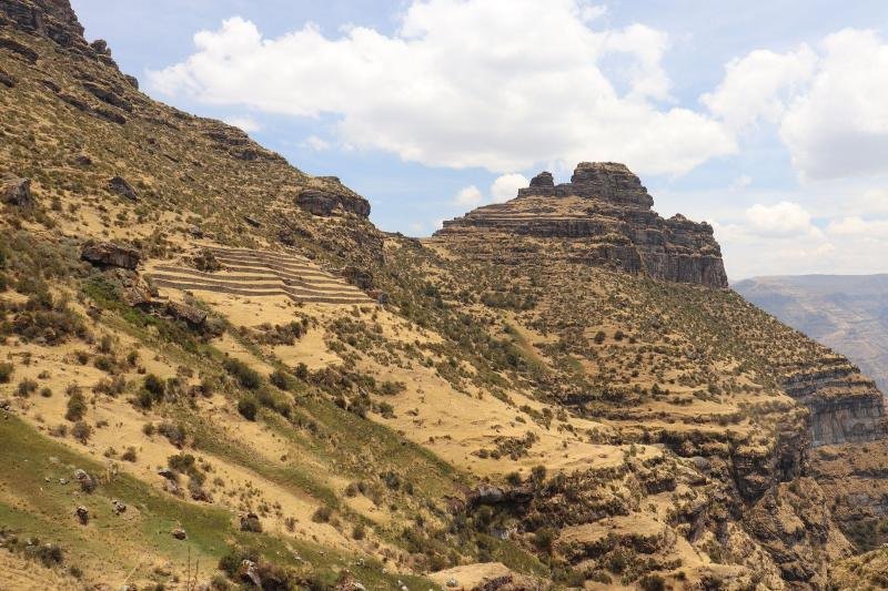 Waqrapukara fortress on a rock spur above the canyon, with terraces on the slope