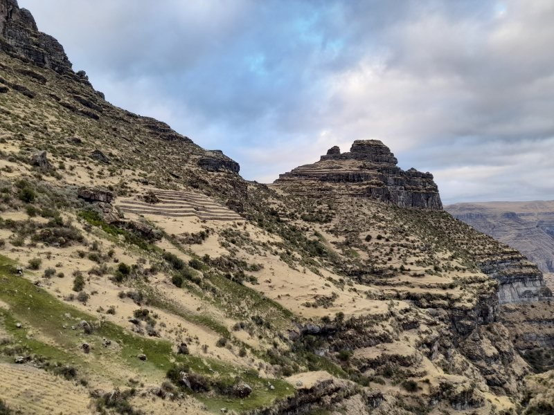 Approach to Waqrapukara with its rock spur and terraces across the slope