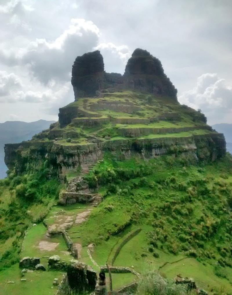 The two rock horns of Waqrapukara above green terraces